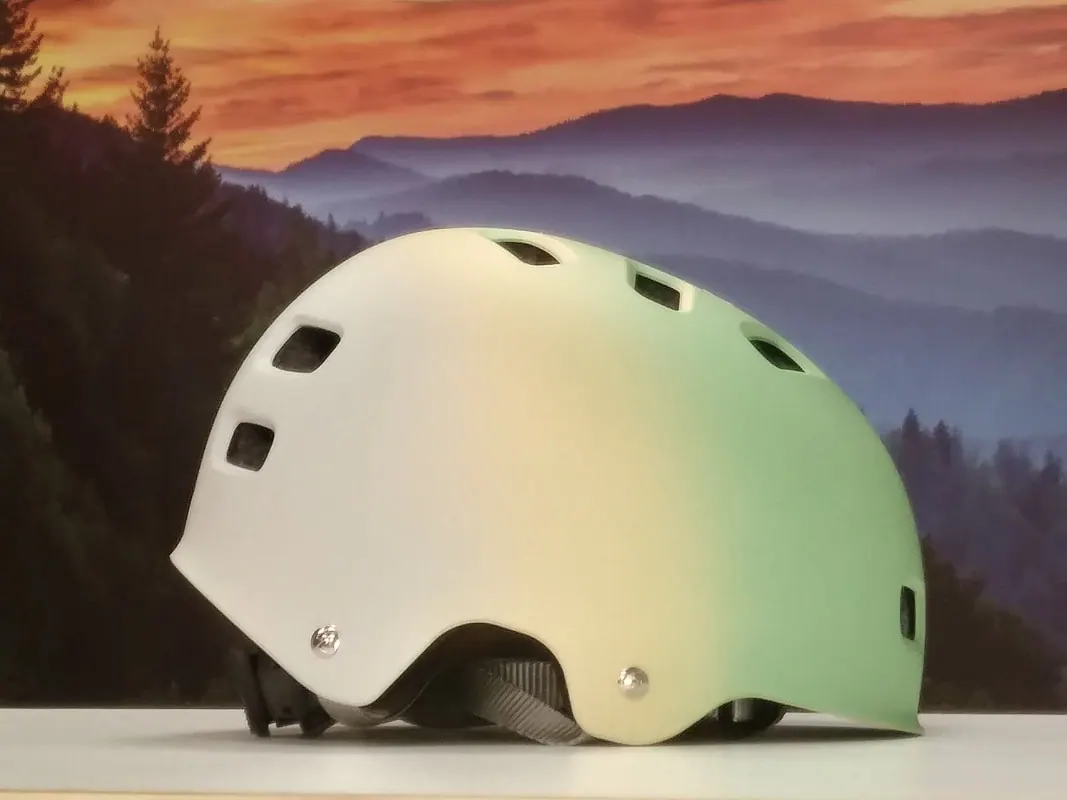 E-bike helmet in a white-to-green fade, on display at the shop