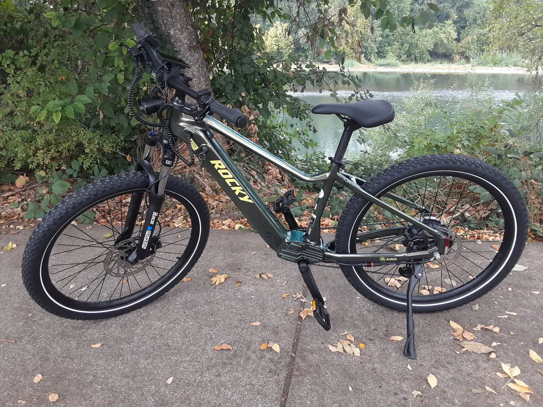 Rocky e-bike in black by a riverside park